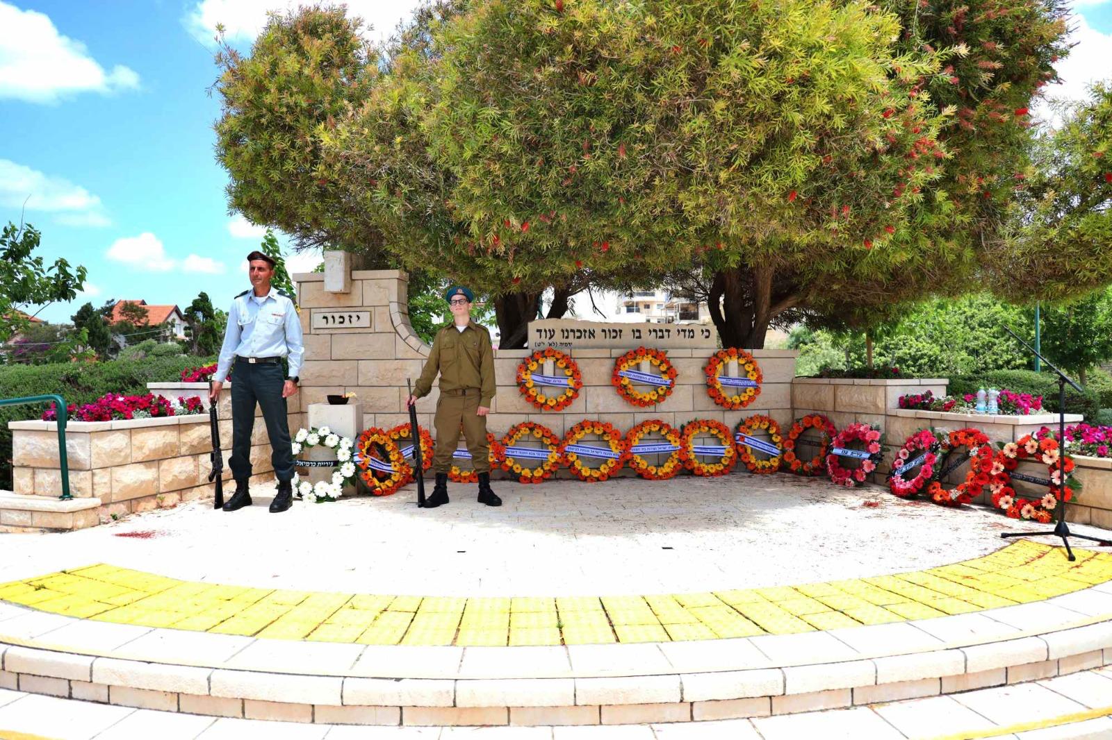 יום הזיכרון בבית העלמין הצבאי חיילים אוחזים בנשק לצד זרי פרחים 