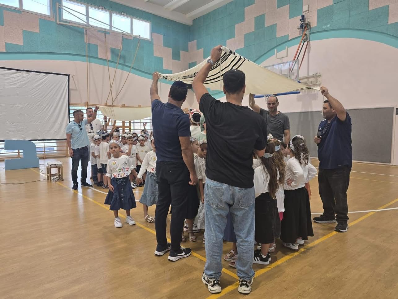 מחזיקים תלית ומברכים את הילדים שפותחים את שנת הלימודים החדשה